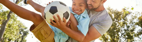 Black and white soccer ball being held during a playful moment.