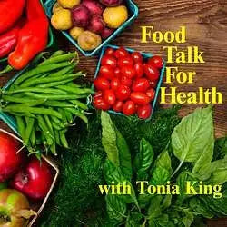 Fresh red tomatoes, green beans, and leafy greens arranged in colorful wooden crates.